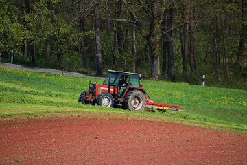 Farmer with tractor on cropland cultivating soil (Swabian Alp, Germany)