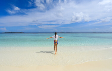 Fototapeta na wymiar girl on the coast of a tropical island looking at the sea