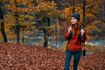 Autumn forest nature landscape tall trees and woman hiker with backpack