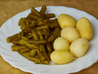Tasty Green beans and potatoes on a plate on a brown napkin