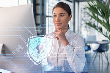 Attractive businesswoman in white shirt at workplace working with laptop to defend customer cyber...