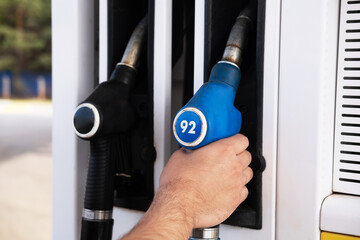 Refueling the car with fuel. There are black and blue pistols on the gas pump for refueling the car...