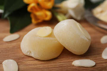 Delicious mochi and almond flakes on wooden table, closeup. Traditional Japanese dessert