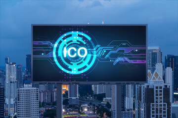 ICO hologram icon on billboard over panorama city view of Kuala Lumpur at night. KL is the hub of...