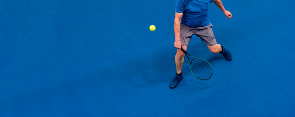 Man playing tennis on blue floor. Professional sport concept