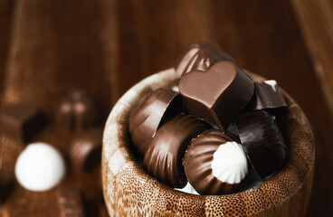 Detail shot of two heart-shaped chocolates in their golden box. International Chocolate Day. Copy Space