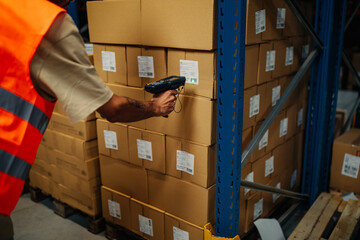 Warehouse manual worker scanning cardboard box