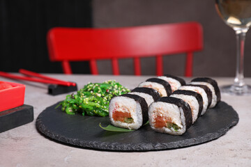 Tasty sushi rolls with salmon served on light table