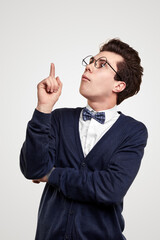 Nerdy young man pointing up