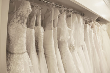 Different wedding dresses on hangers in boutique