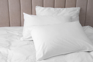 Fototapeta na wymiar White soft pillows on comfortable bed indoors