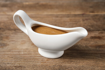 Delicious turkey gravy in sauce boat on wooden table