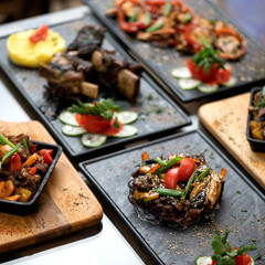 Meat and vegetables dishes on restaurant dining table. Variety of delicious and healthy vegetarian food. Set lunch. Hearty meals. Square format or 1x1. Soft focus.