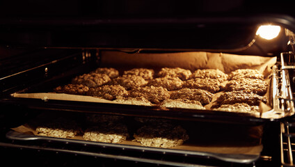 Baking tray with chip oatmeal cookies in oven. Homemade dessert. Culinary recipe with oat flakes. Useful confection. Diet bakery. Low calories. Hot oven. Concept of cozy home. Fresh sweet home bake