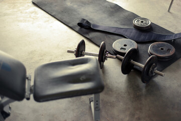 dumbbells and workout equipment in home garage
