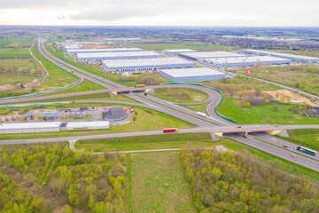 Aerial view of goods warehouse. Logistics center in industrial city zone from above. Aerial view of trucks loading at logistic center. View from drone.