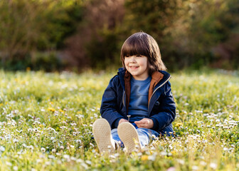 Little child sitting on grass outdoors