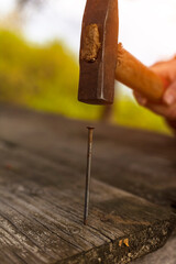 Close-up of hammering a nail into the board. 