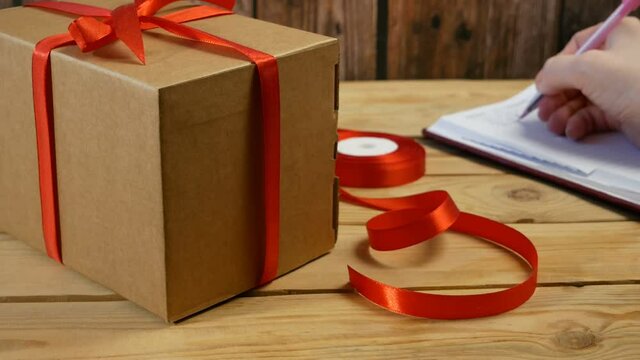 Gift parcel box with ribbon red bow, brown carton parcel, surprise