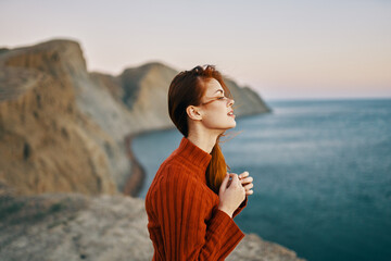 woman in red sweater near the sea side view mountains fresh air
