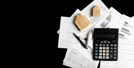 Banner with two wooden houses, pile of working documentation, calculator and pen isolated on black background. Concept of mortgage loans, search for money to buy house, growth of real estate prices.