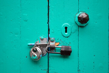 Metal Padlocks & Hasp On Green Painted Wooden Door 