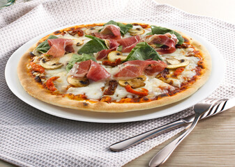 Pizza de jamón serrano y champiñones  con cubiertos. Serrano ham and mushroom pizza with cutlery.