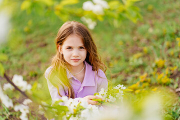 Naklejka na ściany i meble Beautiful kid girl with a branch of a flowering tree. natural cosmetics