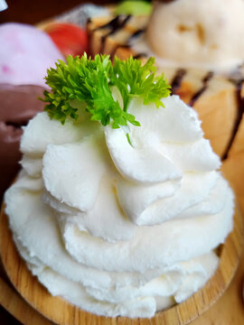 Whipped cream with  prasley leafs in wood cup.