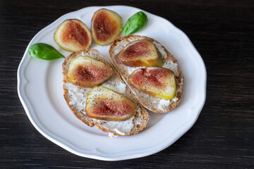 Bruschettas with figs and gorgonzola on white plate, closeup