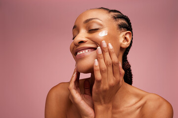 Woman applying beauty product on face