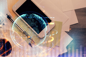 Double exposure of map hologram drawing over desktop. Top view. International connection concept.