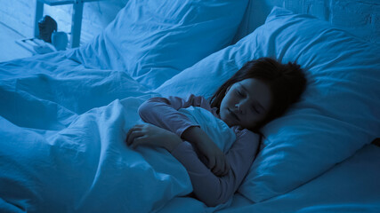 Preteen child sleeping in bedroom at night