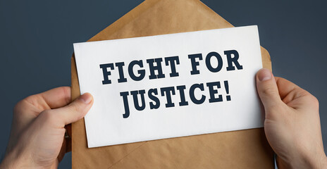 Closeup of a male hands holding craft envelope with text Fight for Justice on blue background
