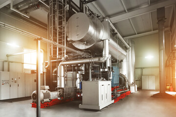 Rankine organic cycle turbine (ORC-turbine) installed in modern industrial boiler room with control cabinets, equiped for heating process with sun flares. © Aliaksei