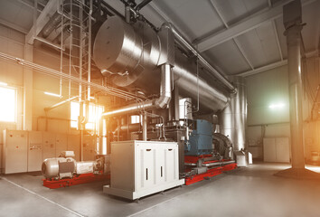Rankine organic cycle turbine (ORC-turbine) installed in modern industrial boiler room with control cabinets, equiped for heating process with sun flares.