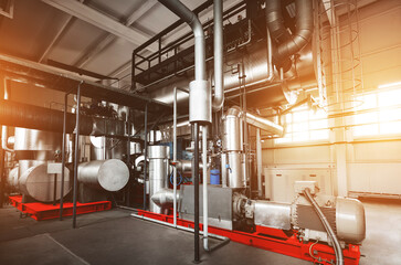 Rankine organic cycle turbine (ORC-turbine) installed in modern industrial boiler room with control cabinets, equiped for heating process with sun flares.
