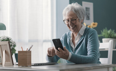 Smiling senior lady using her smartphone