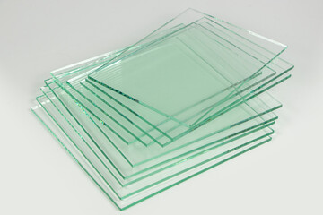 Sheets of Factory manufacturing tempered clear float glass panels cut to size. White background