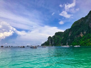 Fototapeta premium Smaragdgrünes Meer in Thailand mit Speedbooten und Vulkaninseln bei bestem Wetter