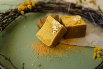 handmade soap of gold color close-up on a green background