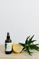 hydrolat cut lemon and aloe on a wooden table on a white background