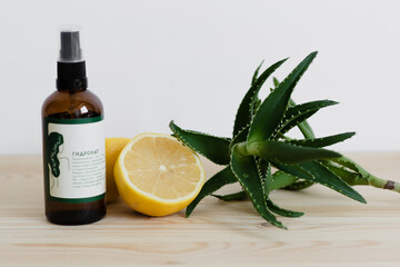 hydrolat cut lemon and aloe on a wooden table on a white background