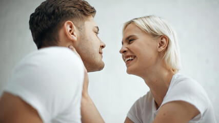Fototapeta premium cheerful woman smiling while looking at happy boyfriend