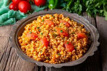 Traditional turkish bulgur pilaf with tomato sause in plate (Turkish name; meyhane pilavi)
