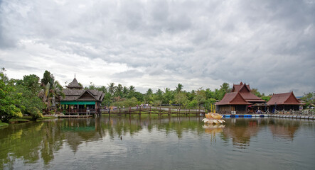 Fototapeta premium Lake in the park. Tourists drink tea and look at fish in the water