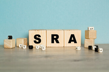 the word SRA are written on a wooden cubes structure. Cube on a bright background. Can be used for...