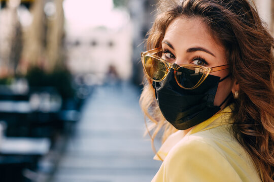 Portrait of young woman with protective face mask and sunglasses