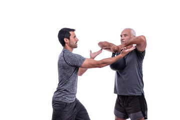 Elderly male client exercising with a fitness trainer, raises dumbbell. On a white isolated background.