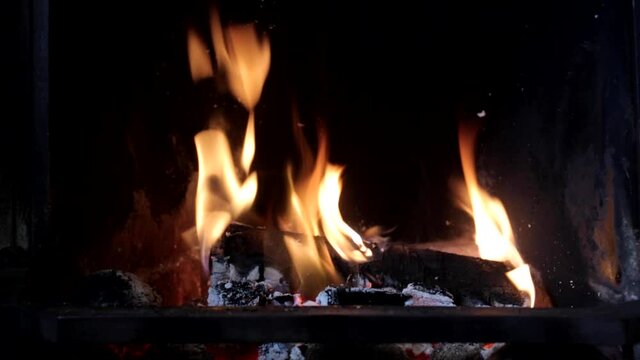 Extreme close up of the flames of a traditional fireplace with a roaring log fire burning in the living room.